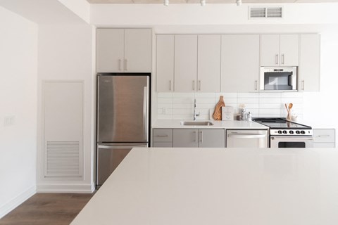 a white kitchen with stainless steel appliances and white cabinets